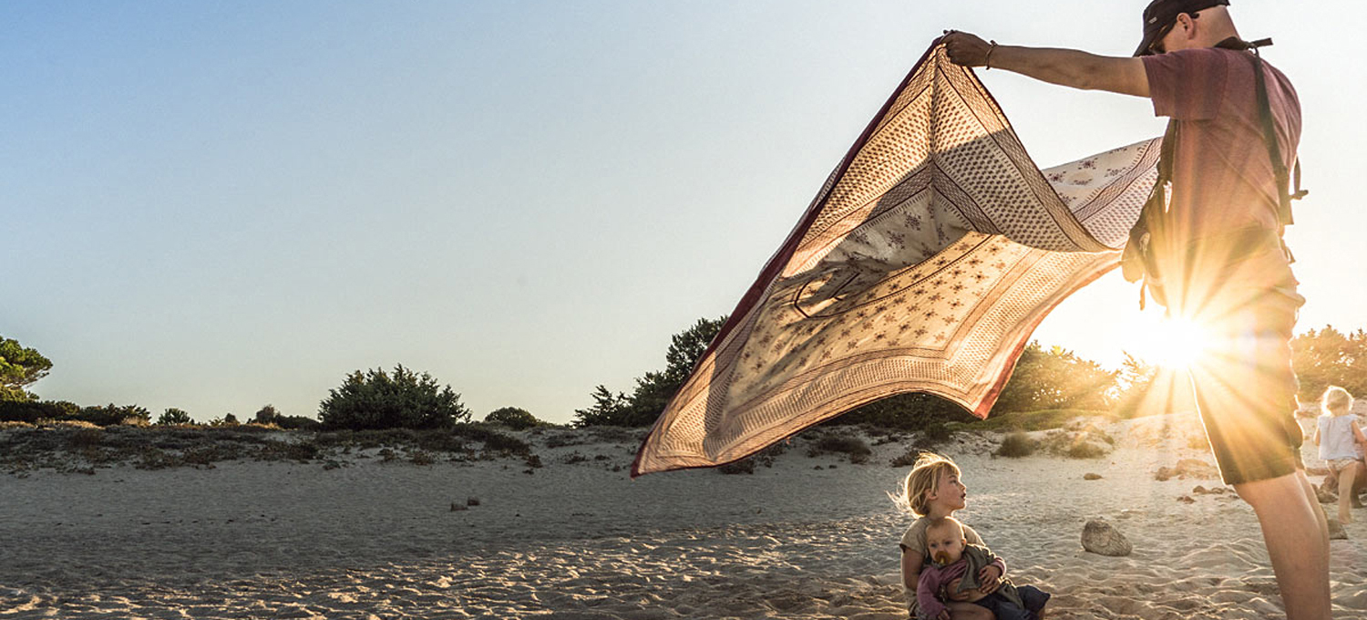 Life-for-Five-Pack-System-Papa Daniel am Strand wedelt ein Strandtuch über seine Töchter